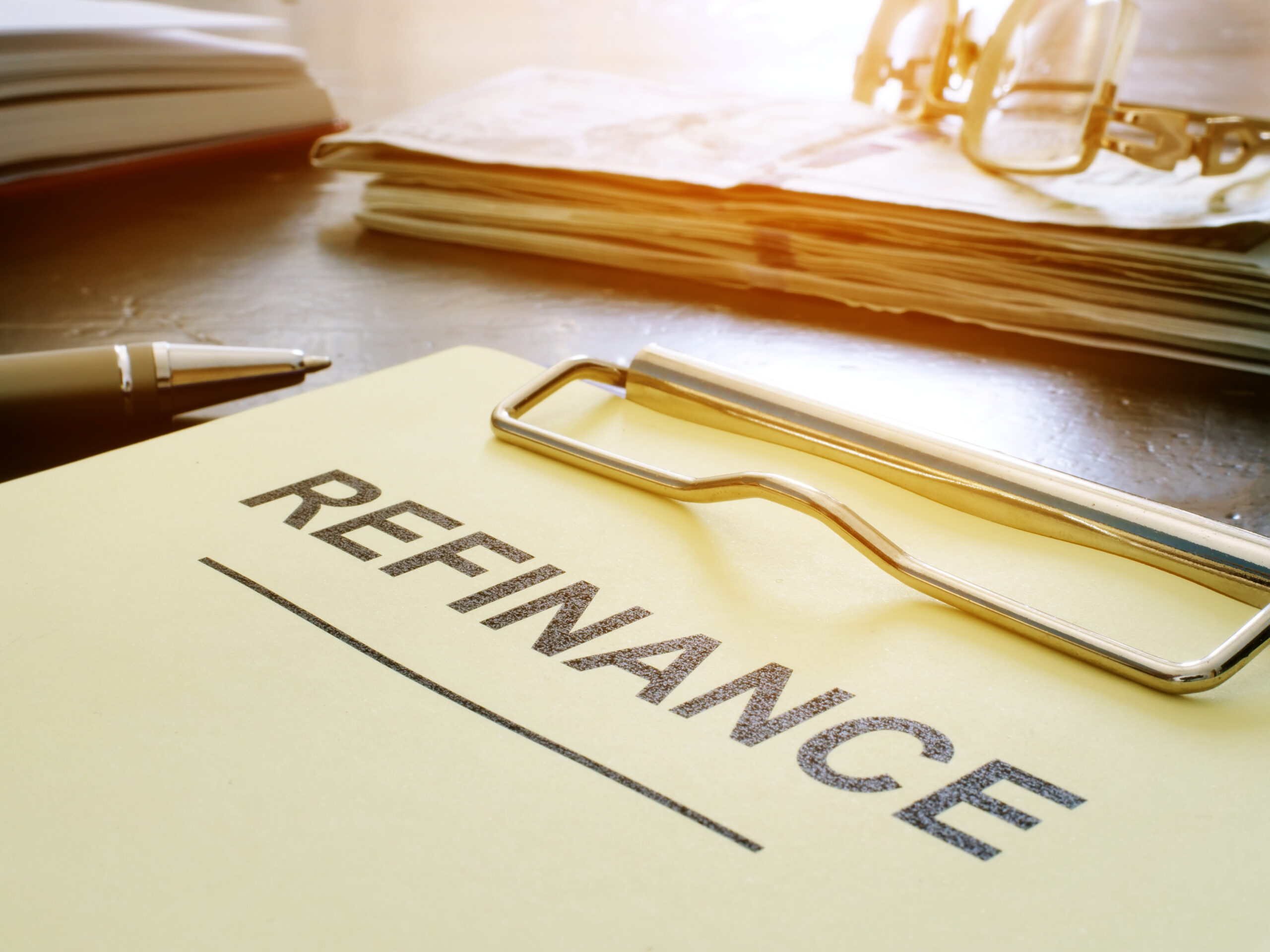 A document with the word "Refinance" highlighted, symbolizing mortgage refinancing options and benefits.